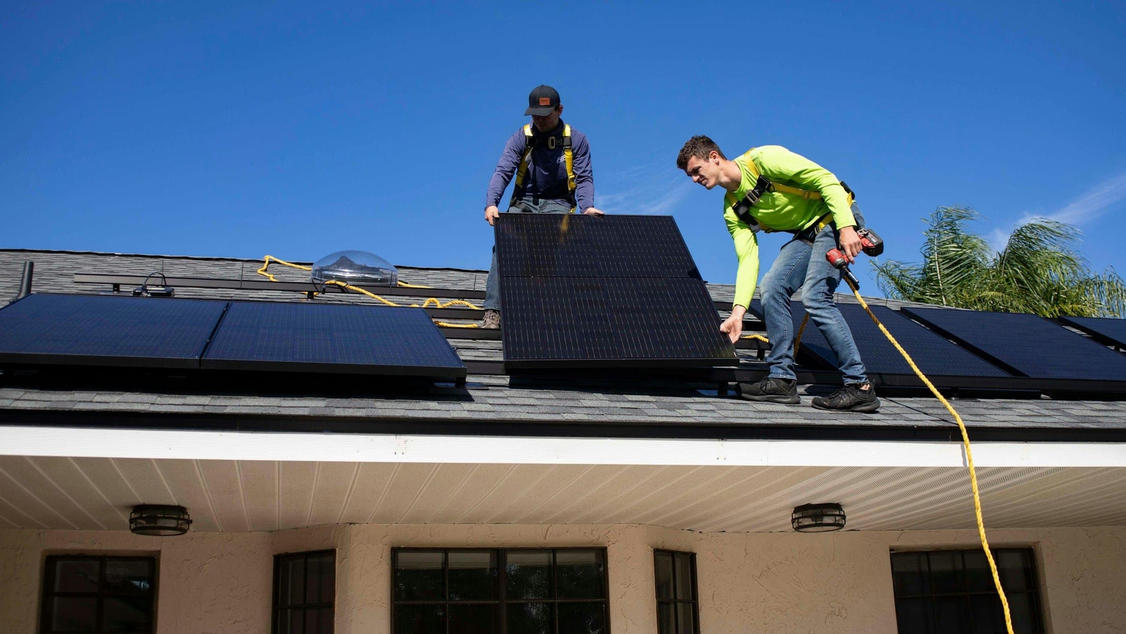 Installateurs posant des panneaux solaires sur une toiture
