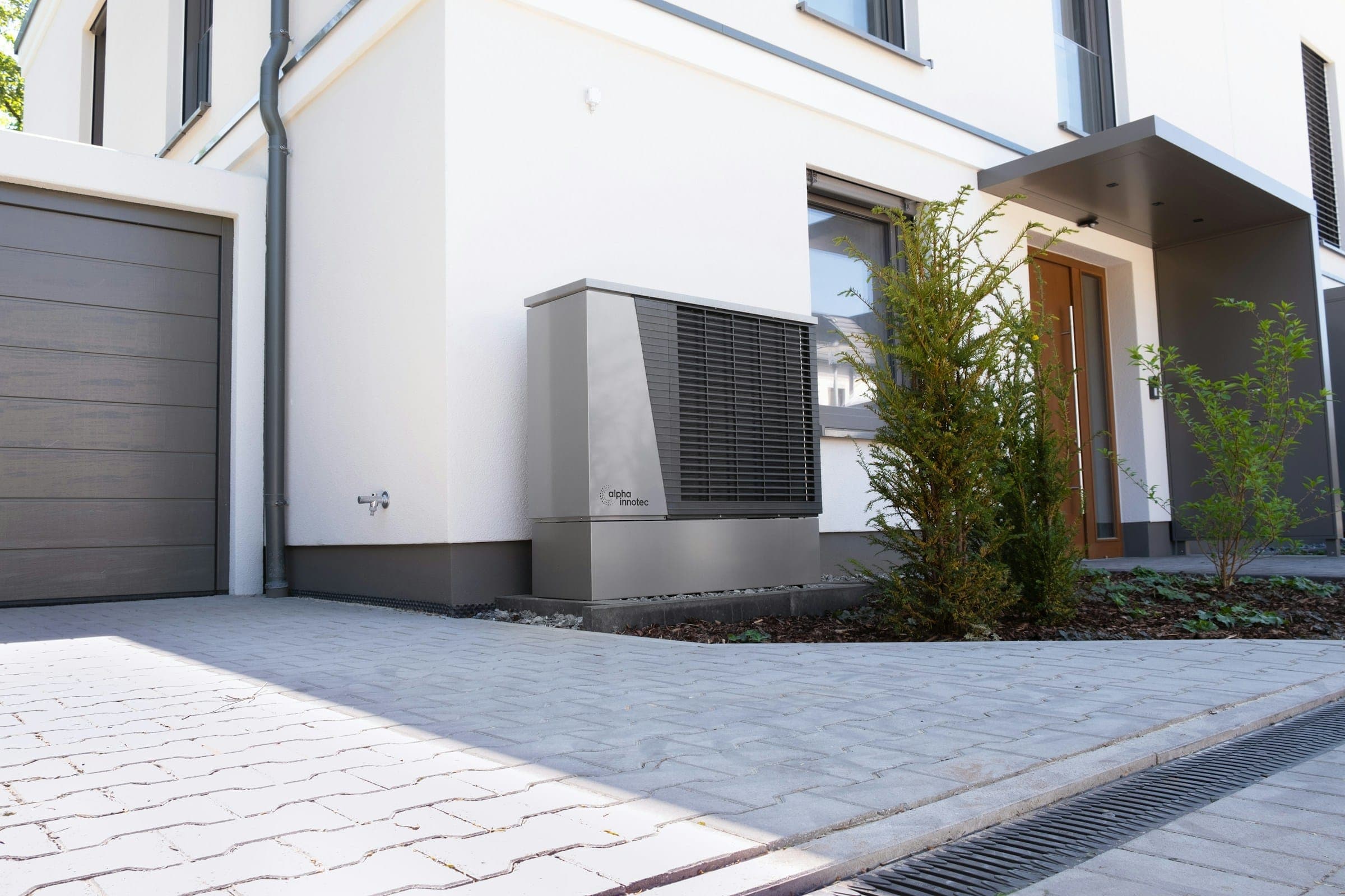 Pompe à chaleur installée devant la façade d’une maison contemporaine