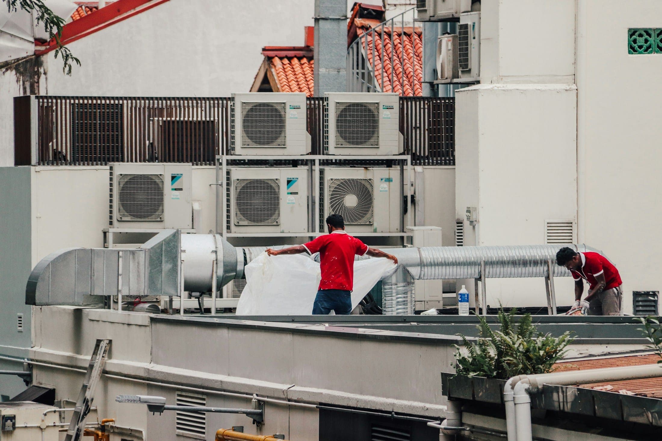 Techniciens intervenant sur des unités de climatisation en toiture